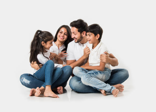 Young Indian/asian family sitting isolated over white background. selective focus