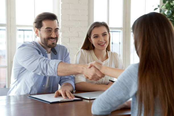 Congratulations, you are hired! Friendly man and woman employers hr colleagues greeting with handshaking young female new team member just accepted on vacancy to corporate stuff by interview results