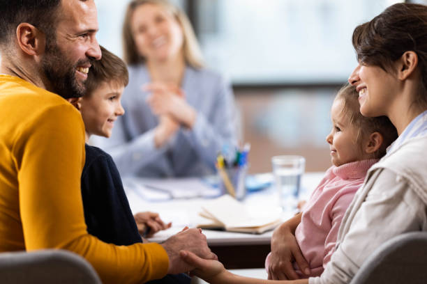 Happy parents and their children having a meeting at family therapist in the office.