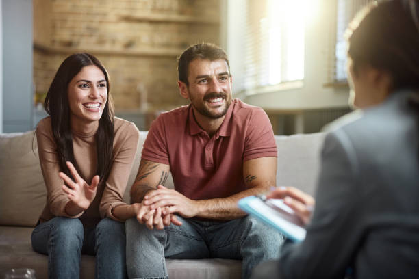 Young happy couple talking about their love with a marriage counselor at home.